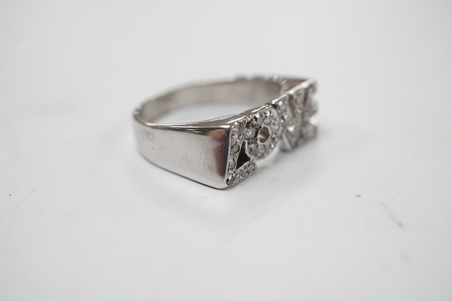 A white metal and diamond chip cluster set 'LOVE' ring, size J, gross weight 3.4 grams. Condition - fair